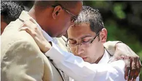  ??  ?? Suddenly widowed: A friend consoling Adatia’s husband Ketan Sood (right) during her funeral. — EPA