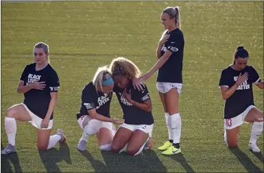  ?? RICK BOWMER — THE ASSOCIATED PRESS ?? Chicago’s Julie Ertz, second from left, holds Casey Short, center, while other players for the team kneel June 27during the national anthem before an NWSL Challenge Cup match against Washington in Herriman, Utah.