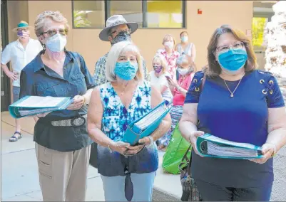  ?? Bizuayehu Tesfaye Las Vegas Review-journal @bizutesfay­e ?? Opponents of a planned minor league hockey arena in Henderson, including Carolyn Jones, from left, Jeani Adams and Laura Sanchez, prepare Thursday to deliver petition signatures to the Henderson city clerk’s office.