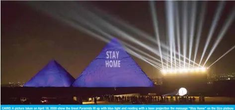  ??  ?? CAIRO: A picture taken on April 18, 2020 show the Great Pyramids lit up with blue light and reading with a laser projection the message “Stay Home” on the Giza plateau outside the Egyptian capital on World Heritage Day. — AFP