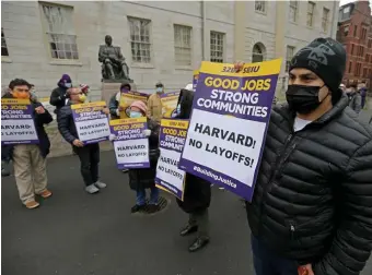  ?? STUART CAHILL PHOTOS / HERALD STAFF ?? ‘NO LAYOFFS’: Union workers hold up signs Thursday as they protest layoffs at Harvard University in Cambridge.