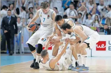  ??  ?? EQUIPO. Doncic, Ayón y Llull se vuelcan con Carroll, en el suelo tras anotar el 3+1 decisivo para el 2-1.