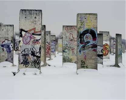 ??  ?? SOTTO . Blocchi di cemento del Muro di Berlino in “Schnee von Gestern”, la foto del 2013 di Ludwig Rauch, padre di David Mallon, riprodotta sulla T-shirt Bridges Over Walls di SOUVENIR OFFICIAL (in basso).