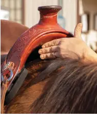  ??  ?? LEFT: Your horse’s withers and shoulders need to be able to move, which is why I use the three-finger rule to check wither clearance. To do this, hold your index, middle, and ring fingers straight out with your thumb pointing to the sky, and slide your hand between the underside of your saddle pommel and the top of the withers.