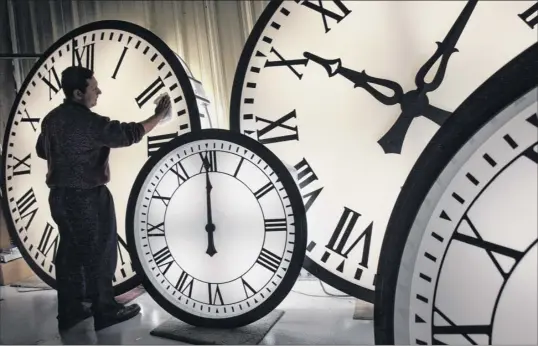  ?? Elise Amendola / Associated Press ?? Electric Time Co. employee Walter Rodriguez cleans the face of an 84-inch Wegman clock at the plant in Medfield, Mass., in this 2008 photo.