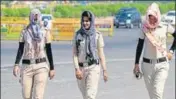  ?? YOGENDRA KUMAR/HT PHOTO ?? Haryana Police personnel cover their faces to protect themselves from heat in Gurugram on Monday.