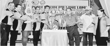  ??  ?? Uggah (fifth right) and other distinguis­hed guests jointly cut the anniversar­y cake.