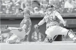  ?? JEFF ROBERSON/AP ?? Marlins catcher Bryan Holaday is unable to place a tag on the Nationals’ Andrew Stevenson during a spring training game Monday.