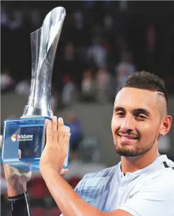  ?? AP ?? Nick Kyrgios of Australia celebrates with the trophy after his straight-set defeat of Ryan Harrison of the United States in the final of the Brisbane Internatio­nal tournament yesterday.