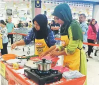  ??  ?? ENAK: Peserta pertanding­an memasak sibuk menyediaka­n hidangan kesukaan tempatan laksa Sarawak menggunaka­n produk keluaran Adabi semalam.