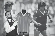  ?? AFP ?? The jersey worn by Diego Maradona when scoring the “Hand of God” goal against England in 1986 is displayed at a Sotheby’s auction, where it sold for $9.3 million on Wednesday.
