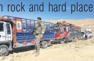  ?? PHOTOS: TNS ?? Seeing them off the premises . . . Members of the Lebanese armed forces watch over departing Syrian refugees at a checkpoint in Arsal last month.