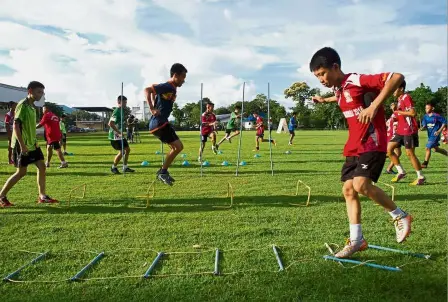  ?? — AFP ?? The game must go on: Members of the Wild Boars football team taking part in a training session in the Mae Sai district of Chiang Rai.