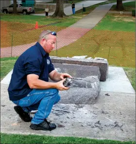  ?? File Photo/Arkansas Democrat-Gazette ?? Secretary of State staff members pick up pieces Wednesday of the the newly-installed 10 Commandmen­ts monument on the State Capitol grounds after it was toppled by a man driving a car.