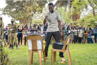  ?? The Associated Press ?? ■ Uganda’s leading opposition challenger Bobi Wine reacts after voting Thursday in Kampala, Uganda. Ugandans are voting in a presidenti­al election tainted by widespread violence that some fear could escalate as security forces try to stop supporters of Wine from monitoring polling stations.