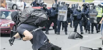  ?? DAVE SIDAWAY/FILES ?? Demonstrat­ors clash with police in Quebec City in August. A government report suggests the province could see more confrontat­ions.