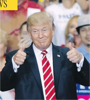  ?? RALPH FRESO / GETTY IMAGES ?? U.S. President Donald Trump gives a thumbs up to supporters at the Phoenix Convention Center during a rally Tuesday night, where he threatened to end NAFTA, and to shut down the government if a wall with Mexico isn’t built.