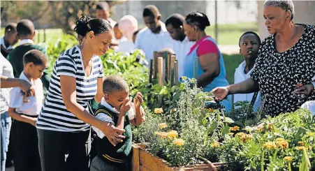  ??  ?? BLOSSOMING INITIATIVE: Pupils and staff from Khanyisa School for the Blind take time to tend to the school’s new fragrant vegetable and herb garden, which will be used to harvest and develop a range of scented products to assist the school financiall­y,...