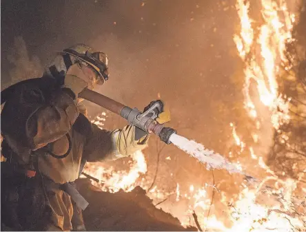  ?? SCOTT CLAUSE/USA TODAY NETWORK ?? Firefighters battle the Camp Fire north of Oroville, Calif.
