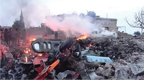  ?? REUTERS ?? TAK SELAMAT: Puing-puing pesawat Sukhoi-25 milik Rusia yang hancur setelah ditembak jatuh kelompok Hayat Tahrir Al Sham di Provinsi Idlib, Syria, pada Sabtu (3/2).