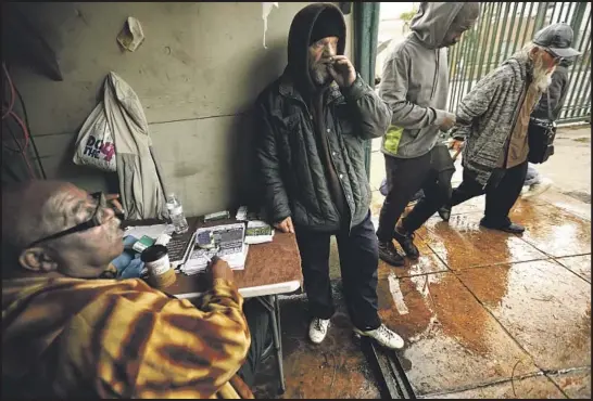  ?? Photograph­s by Genaro Molina Los Angeles Times ?? WENDELL BLASSINGAM­E, 67, left, tries to help recently homeless Rocky Brooks, center, find housing on a rainy afternoon on skid row in downtown Los Angeles.