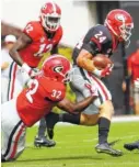  ?? ANDY HARRISON/GEORGIA PHOTO ?? Georgia sophomore inside linebacker Monty Rice (32) makes one of his 14 G-Day tackles Saturday afternoon at the expense of walk-on tailback Prather Hudson (24).