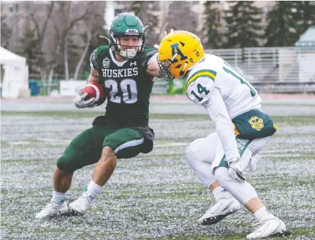  ?? HEYWOOD yu ?? University of Saskatchew­an Huskies Adam Machart tries to straight-arm University of Alberta Golden Bears defensive back Wesley Bookland’s helmet while on his way to establishi­ng a team record for rushing during Usports football action at Griffiths Stadium on Saturday.