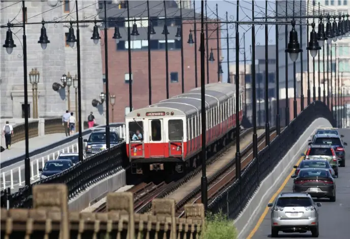  ?? BOsTOn Herald File ?? HELP WANTED: The MBTA says it’s spending large amounts on overtime because it has a high number of job vacancies. A Red Line train crosses the Longfellow Bridge into Cambridge from the city.