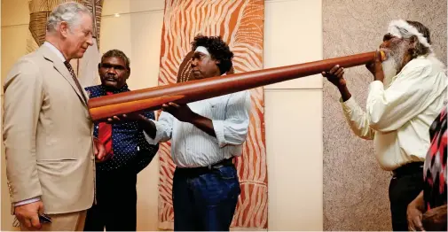  ??  ?? Blow me down! The prince receives a spiritual healing treatment from didgeridoo master Djalu Gurriwiwi