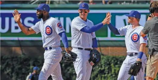  ?? AP ?? Jason Heyward (from left), Anthony Rizzo and Ian Happ celebrate after the Cubs beat the Giants 1-0 on Thursday to tie their high-water mark of 11 games over .500.