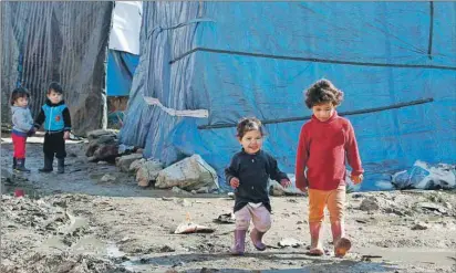  ?? AP PHOTO ?? Syrian refugee children walk outside their family tents at a Syrian refugee camp, in the eastern town of Kab Elias, Lebanon, Wednesday.