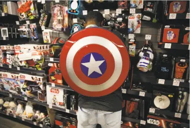  ?? Photos by Santiago Mejia / The Chronicle ?? Kris Jackson, a guest adviser at ThinkGeek, wears a Captain America shield backpack while working.