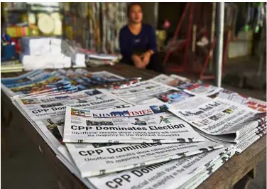  ?? — AFP ?? It’s official: A vendor waiting for customers with newspapers featuring reports on the victory of Hun Sen’s ruling Cambodian People’s Party at a newsstand in Phnom Penh.