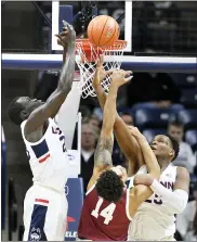  ?? JESSICA HILL — THE ASSOCIATED PRESS ?? Connecticu­t’s Akok Akok, left, and Connecticu­t’s Josh Carlton, right, defend a shot attempt by Temple’s Nate Pierre-Louis, center, in the first half on Wednesday in Storrs, Conn.