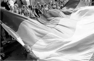  ?? DARKO VOJINOVIC/ASSOCIATED PRESS ?? Gay rights activists hold up a rainbow flag during gay pride march Sunday in Belgrade, Serbia. Holding rainbow flags, balloons and a banner reading “For change,” participan­ts gathered in the central capital before setting off for a march through the...