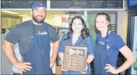  ?? JEREMY FRASER/CAPE BRETON POST ?? Genevieve Andrea, centre, of the Bartown Days Festival, presents James Donato and Amanda Sheffield, co-owners of Commercial Street Deli in North Sydney, with a plaque for winning the Bartown Burger Battle. The best burger was unveiled during the Bartown Days Festival closing concert on Sunday.