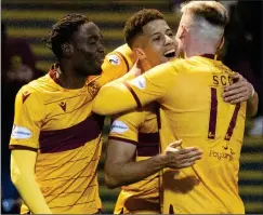  ?? ?? GRIN AND TONIC: Carroll (centre) receives a hug from James Scott for making it 3-0 as fellow-scorer Cole also joins in the celebratio­ns