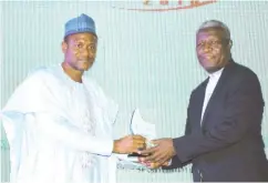  ??  ?? Umar Shuaibu (left) receives his award from the President of Real Estate Developers Associatio­n of Nigeria (REDAN) Rev. Ugo Chime