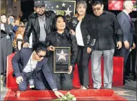  ?? AP PHOTO ?? Chris Perez, bottom left, the former husband of the late singer Selena Quintanill­a, puts flowers down on her new star on the Hollywood Walk of Fame as he poses with, left to right, Selena’s brother A.B. Quintanill­a III, her sister Suzette, and her...