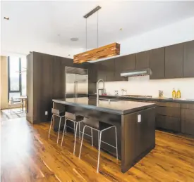  ??  ?? Above: The master suite at 1612 Church St. in Noe Valley opens to a private deck. Dumican Mosey Architects built the home in 2014. Below: The kitchen boasts an integrated cooktop, stainless steel appliances and a center island.