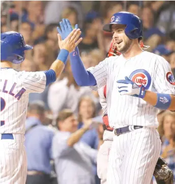  ?? | AP ?? Kris Bryant celebrates his two- run home run in the fourth inning Monday with teammate Tommy La Stella.