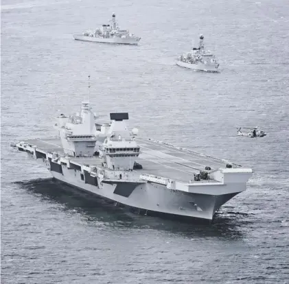  ??  ?? 0 HMS Queen Elizabeth is escorted by two Type 23 frigates – the cost of their replacemen­ts is causing concern