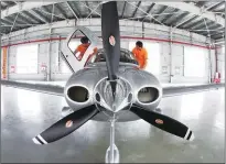  ??  ?? Above and below: The beautiful Jinwan district. Maintenanc­e personnel check the Cirrus SR22 plane, a best seller among small planes.