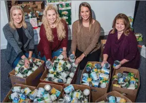  ?? WILLIAM HARVEY/THREE RIVERS EDITION ?? The Junior Auxiliary of Searcy sponsored its annual Food Basket Project to help local families with their Thanksgivi­ng meals. Helping to sort more than 2,000 canned food items collected by students in the Searcy School District are Jessie Hohenstein of...