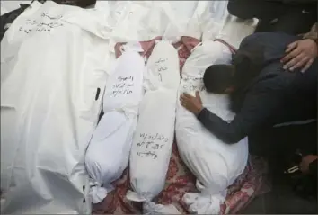  ?? Hatem Ali/Associated Press ?? Palestinia­ns mourn relatives killed in the Israeli bombardmen­t of the Gaza Strip outside a morgue in Rafah, Tuesday.