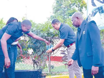  ?? CONTRIBUTE­D ?? Prime Minister Andrew Holness (second right) and Robert Morgan (left), member of parliament for Clarendon North Central, take part in the commission­ing of a water system in Eden, Mocho, in the parish last Friday.