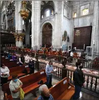  ?? (AP/Rebecca Blackwell) ?? Catholic faithful, wearing masks and practicing distancing during the coronaviru­s pandemic, attend Mass at Metropolit­an Cathedral in Mexico City.