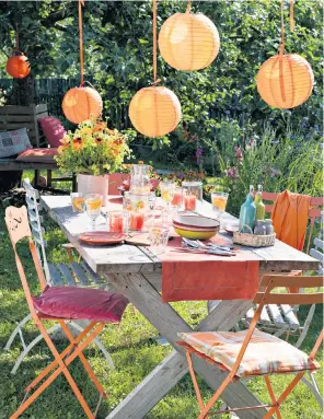  ??  ?? Adding atmosphere: parasols, outdoor lights and chic tableware and furniture are just some of the ways you can spruce up your outdoor space