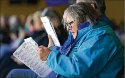  ?? ?? Peggy Janiszewsk­i looks over a race program at Iowa Greyhound Park. Many of those attending expressed disappoint­ment about the track’s closing, lamenting the loss of an entertainm­ent option in Dubuque, a city of about 60,000.