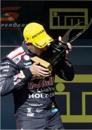  ??  ?? Jamie Whincup kisses the Jason Richards Memorial Trophy after winning the Pukekohe round